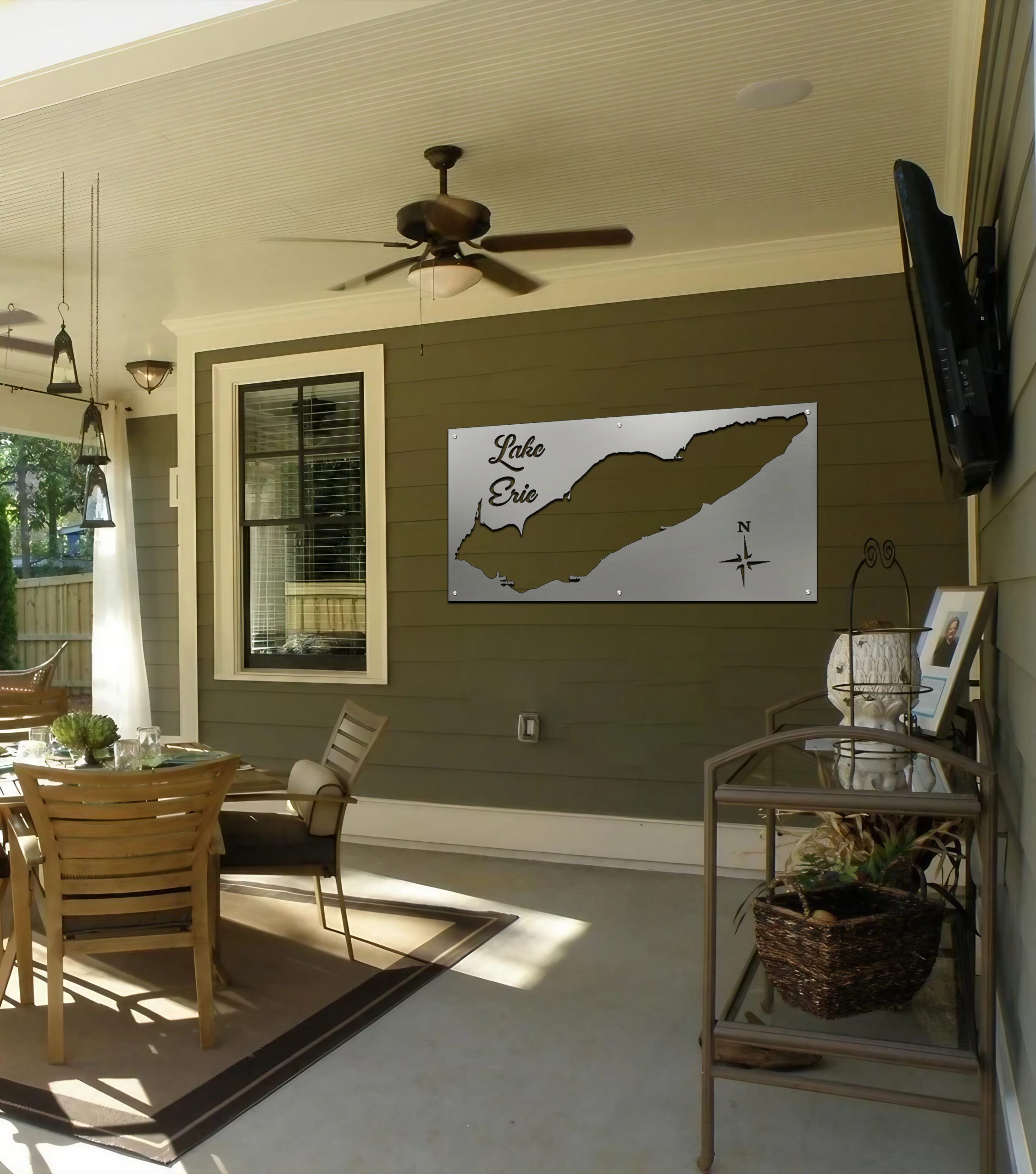 Metal map of Lake Erie displayed on a wall in a covered outdoor seating area.