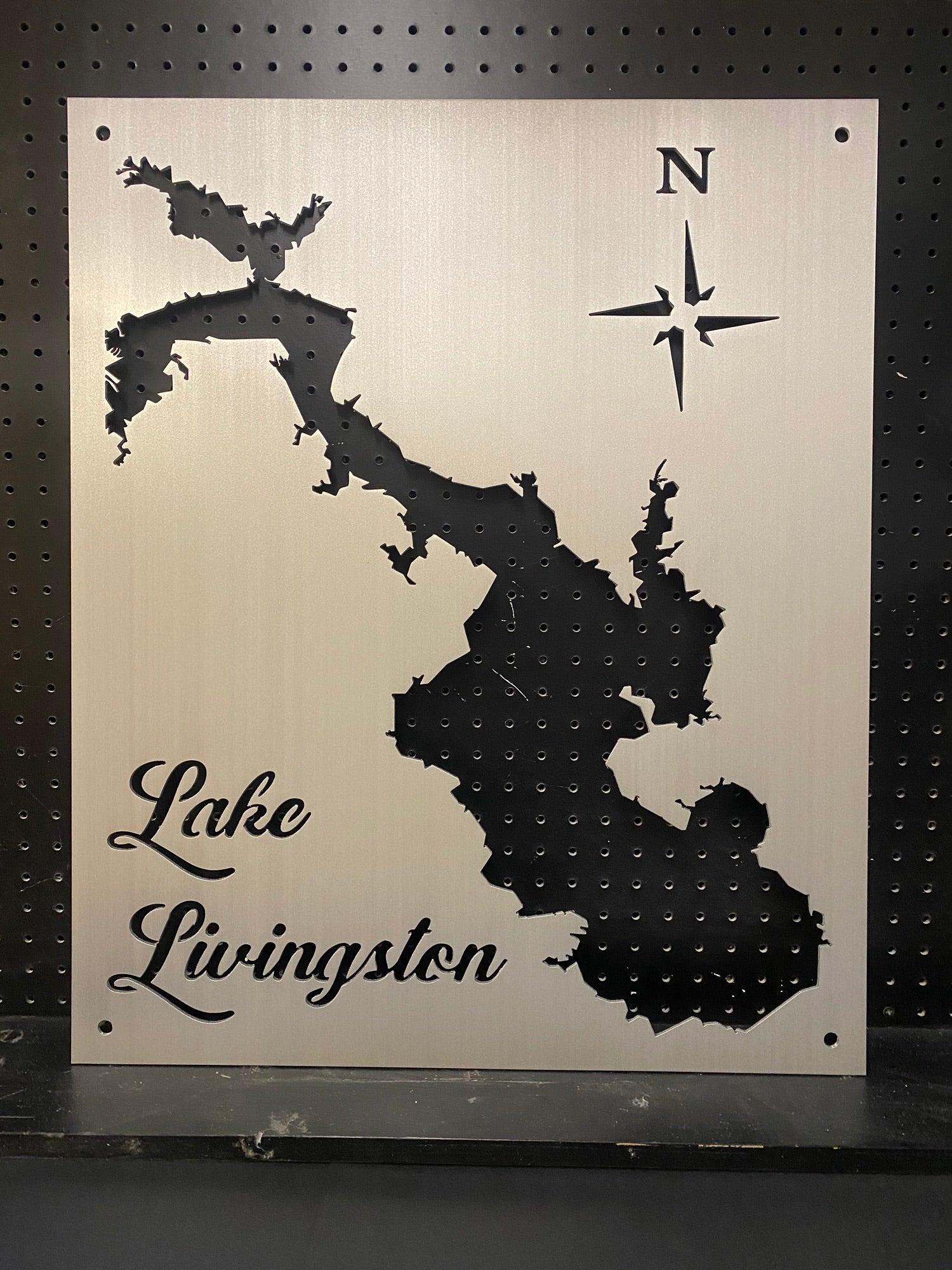 Lake Livingston metal map with compass rose on a perforated black background.