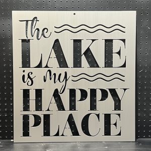 Metal sign with "The Lake is My Happy Place" text and wave design on a perforated black background.