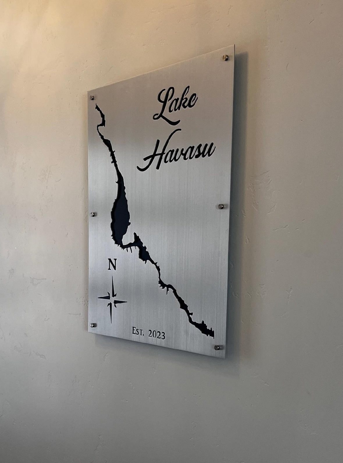 Lake Havasu map sign with silhouette, compass rose, and "Est. 2023" on a textured wall.