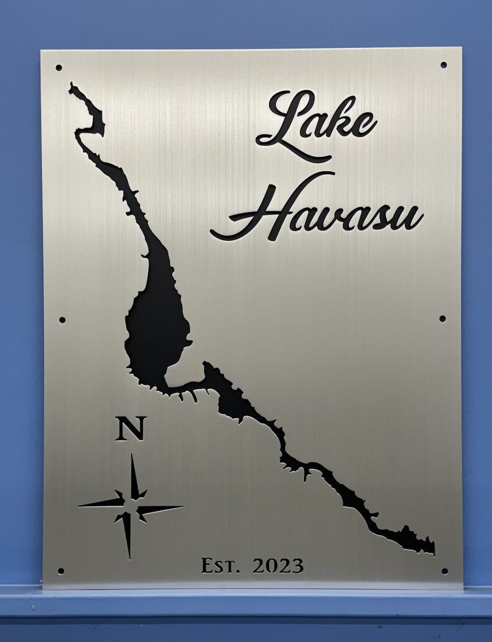 Lake Havasu custom metal sign with lake silhouette, compass rose, and "Est. 2023" on a brushed surface.