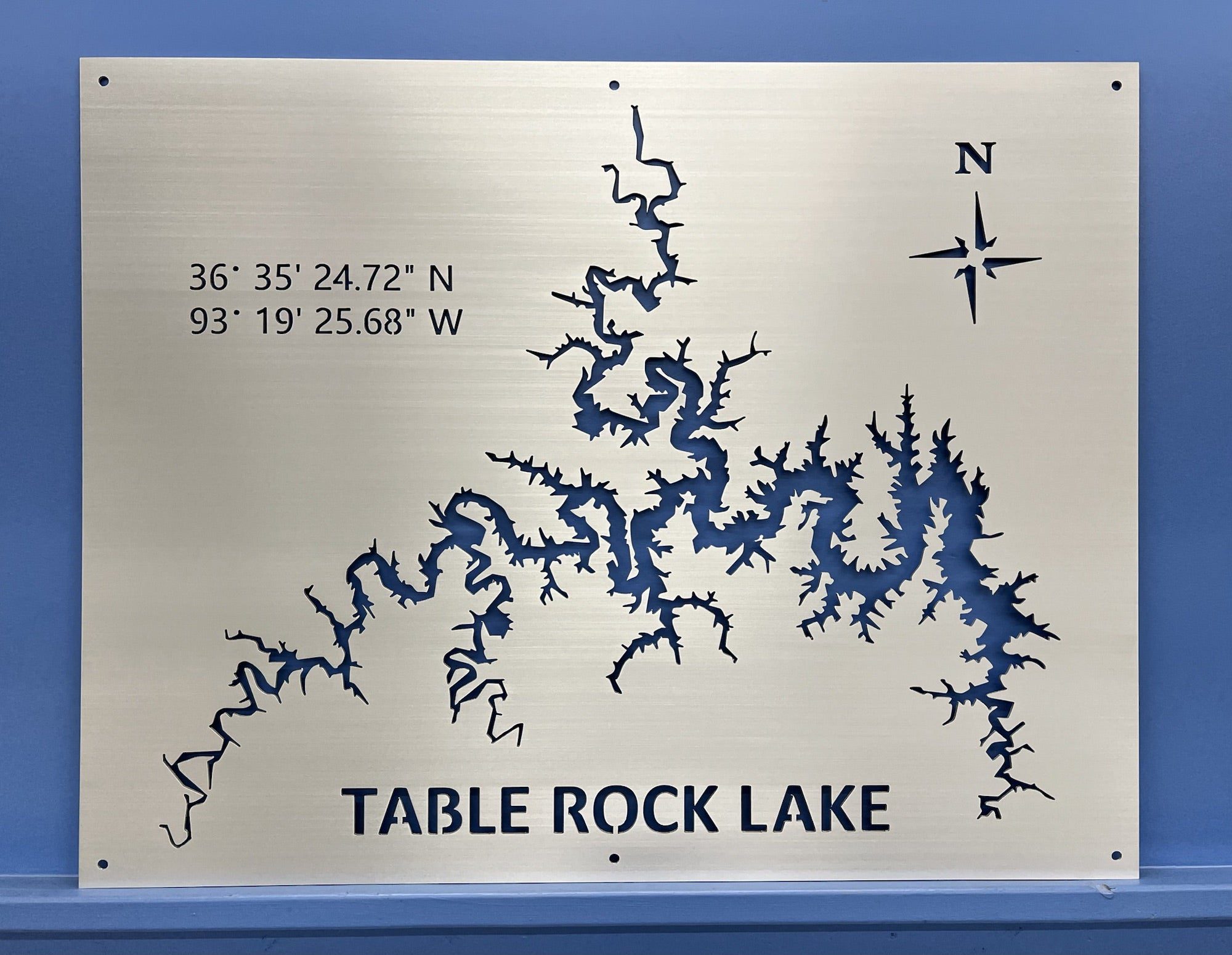 Table Rock Lake metal map with coordinates and compass rose, mounted on a blue wall.