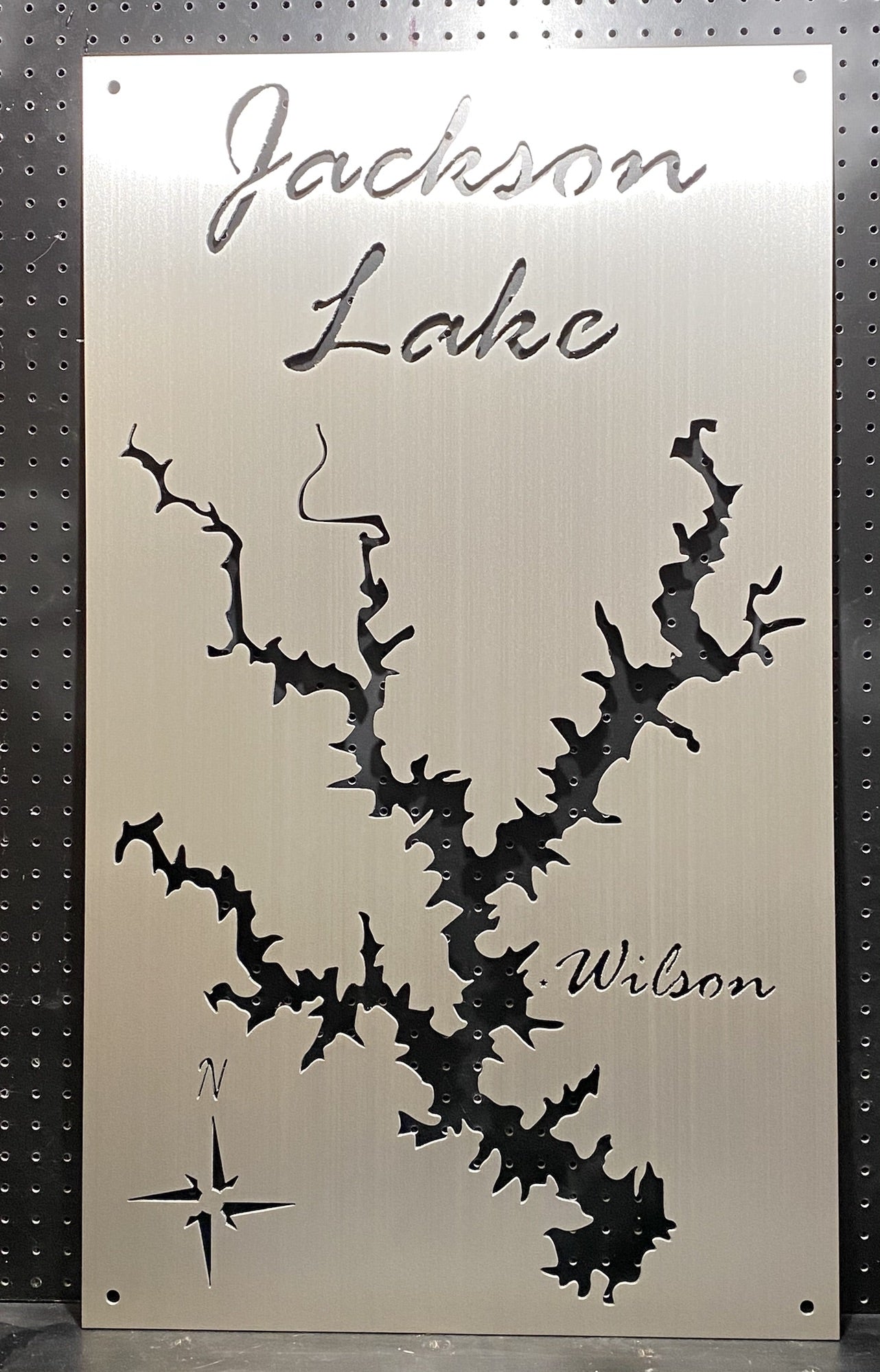Jackson Lake metal map with compass and "Wilson" text, cutout design on a brushed metallic background.