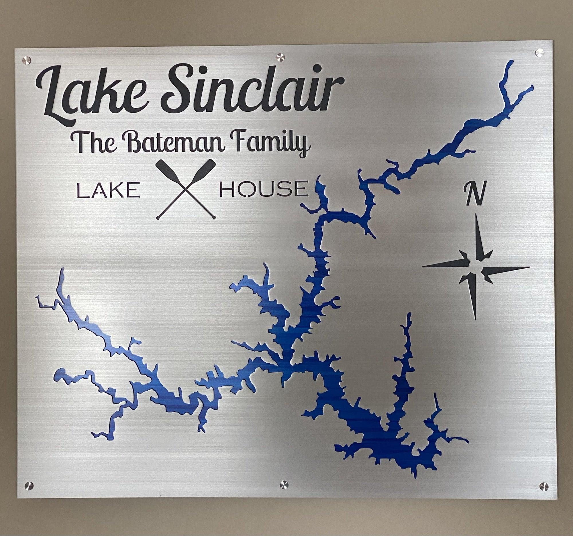 Lake Sinclair metal map sign, "The Bateman Family Lake House" with crossed paddles and compass rose on brushed silver.