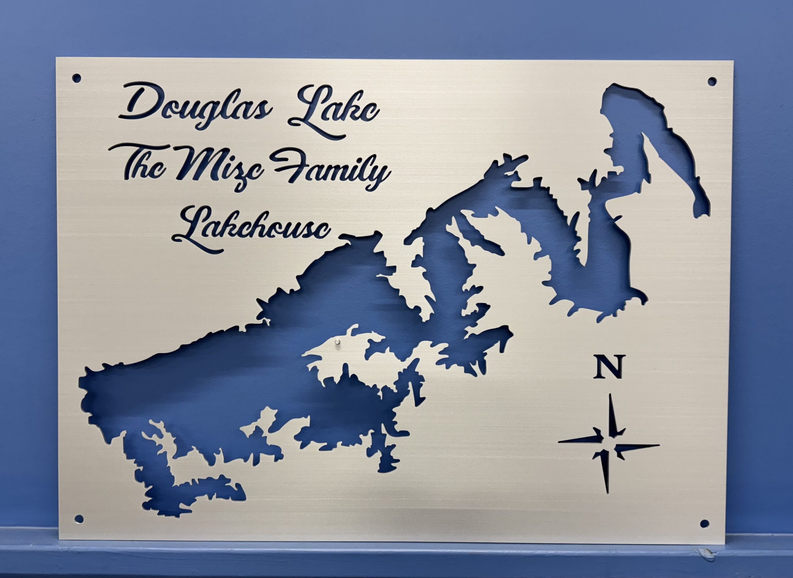 Douglas Lake map cutout with "The Mize Family Lakehouse" text, featuring a compass rose, on a blue background.