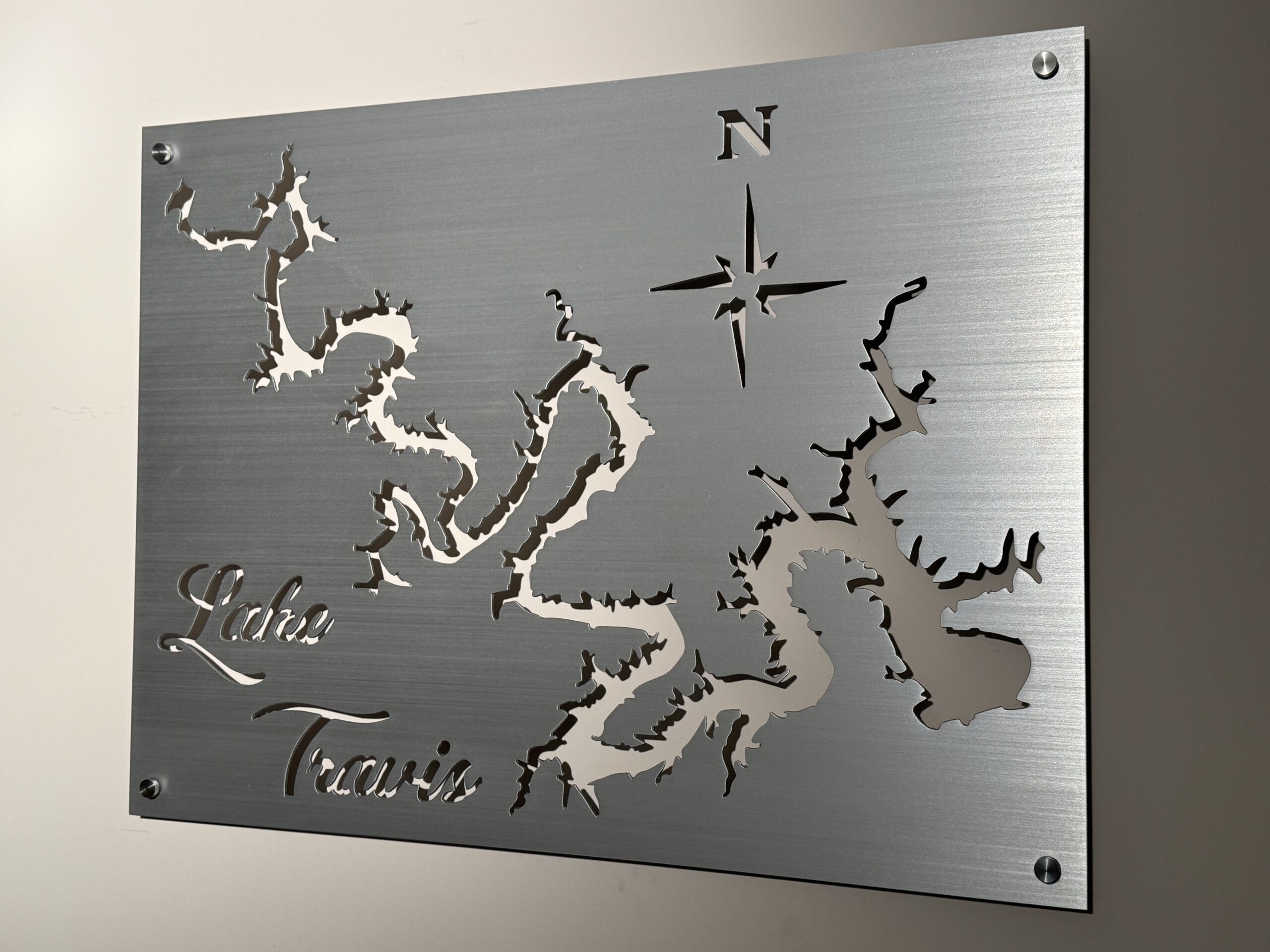 Metal wall art of Lake Travis map with compass rose and "Lake Travis" text in elegant script.