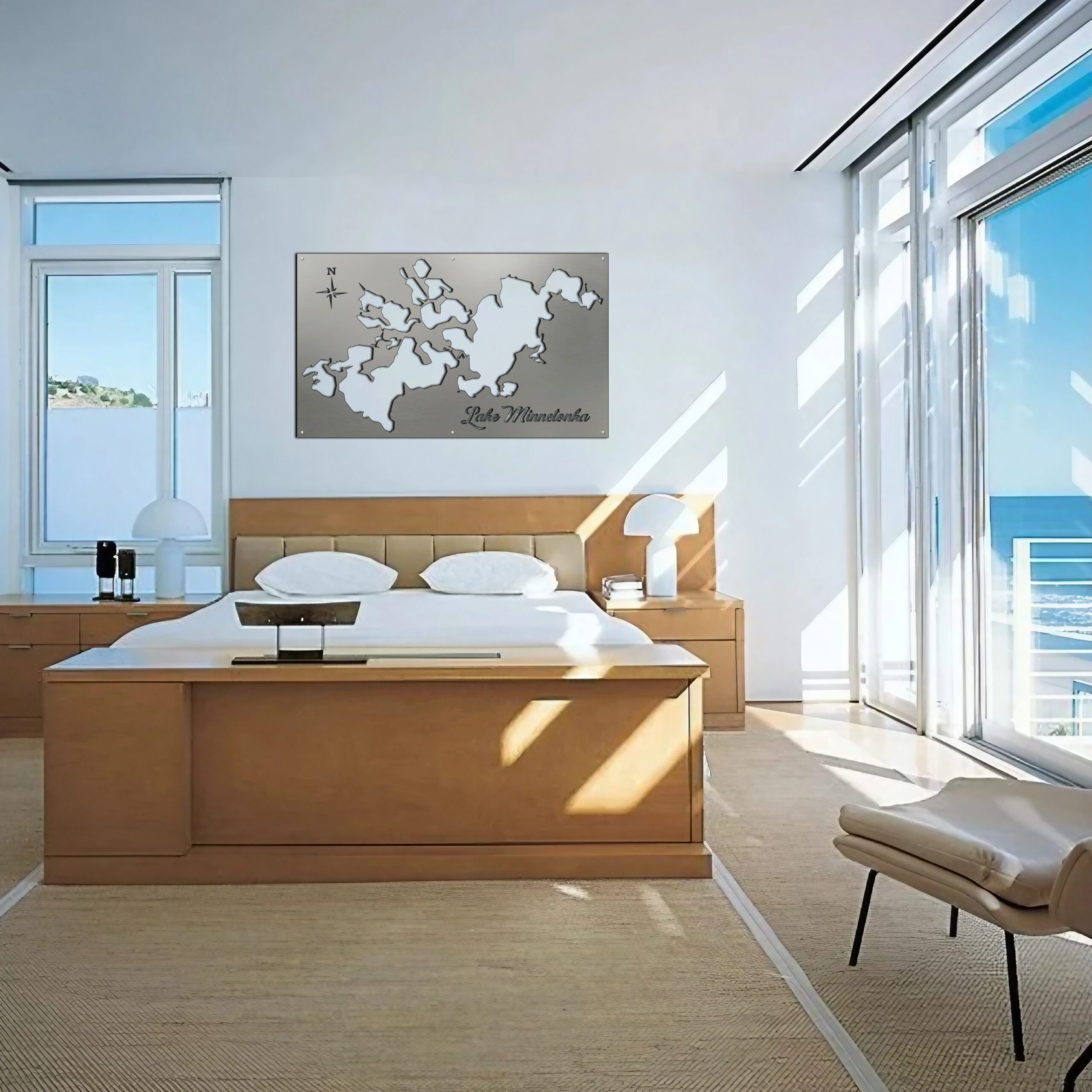 A modern bedroom features a metal map of Lake Minnetonka on the wall above a wooden bed.