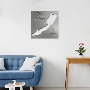 Metal map of Lake Mohawk displayed on a wall above a blue couch and small table with a plant.