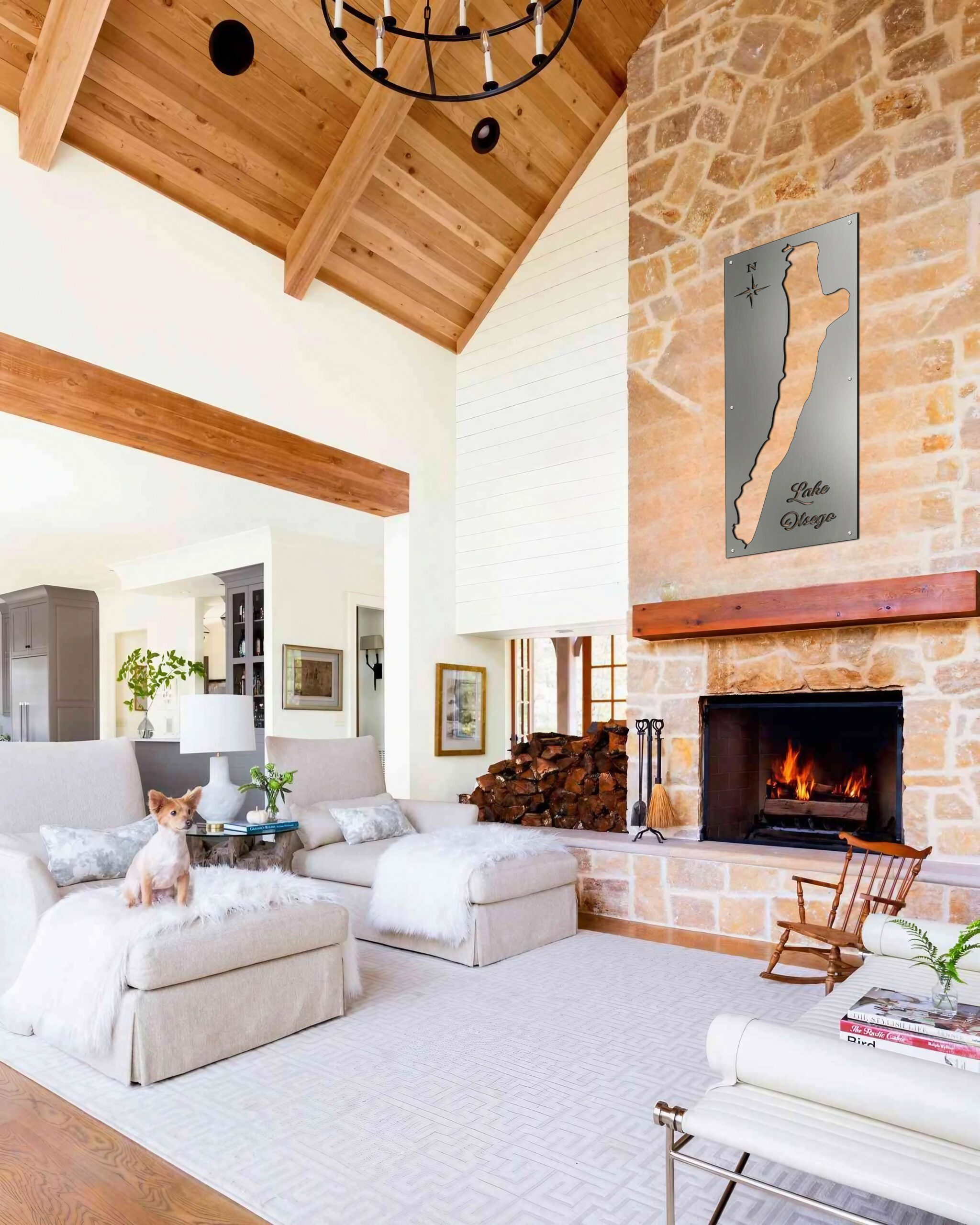 Cozy living room with a metal map of Lake Otsego on the wall, a dog on a chair, and a fireplace.