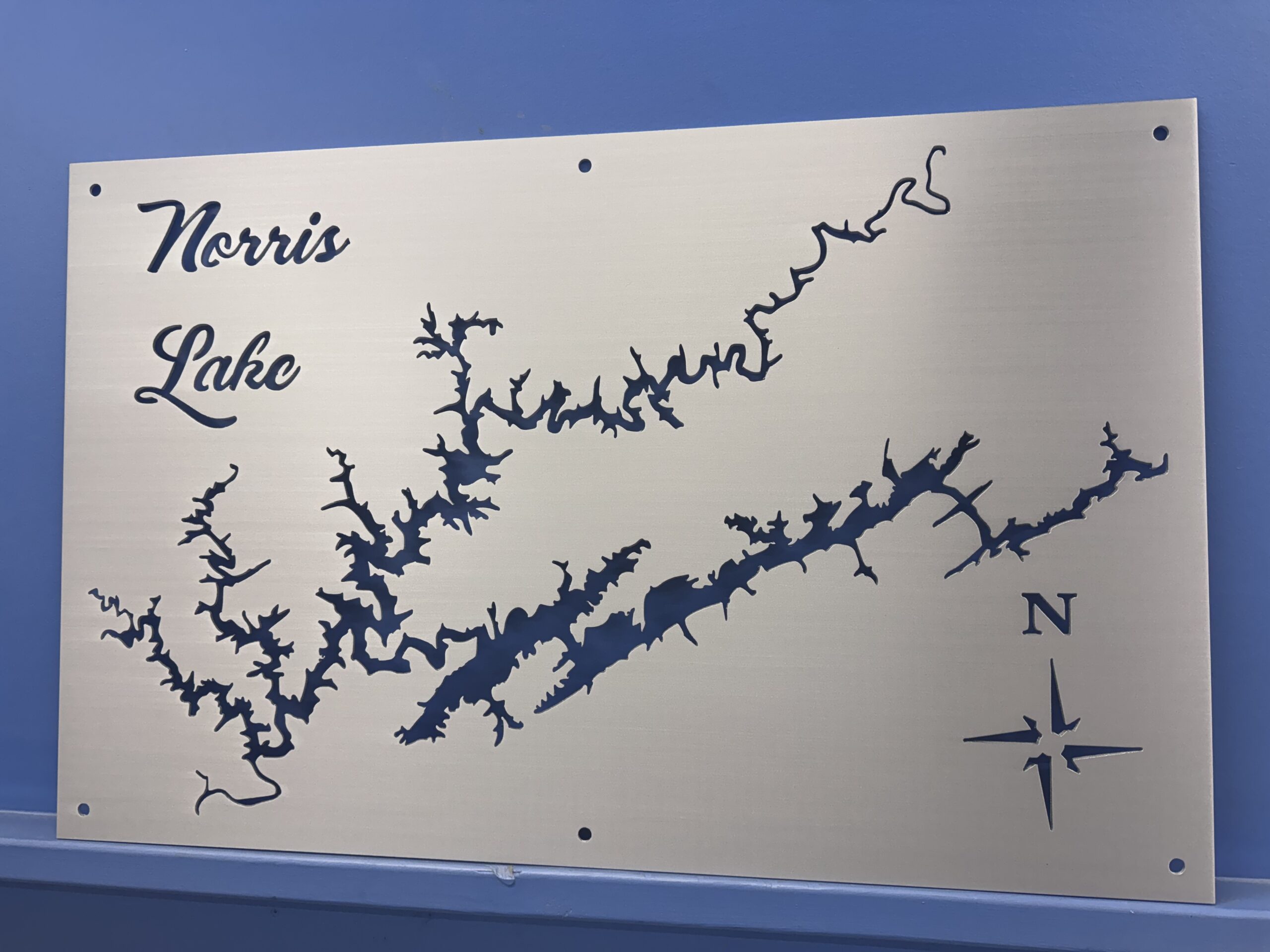 Metal map of Norris Lake with intricate shoreline details and a compass rose.