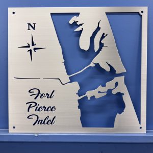 Metal map of Fort Pierce Inlet with a compass rose and decorative lettering.