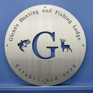 Custom round brushed metal sign for Glenn’s Hunting and Fishing Lodge, with open cutouts.