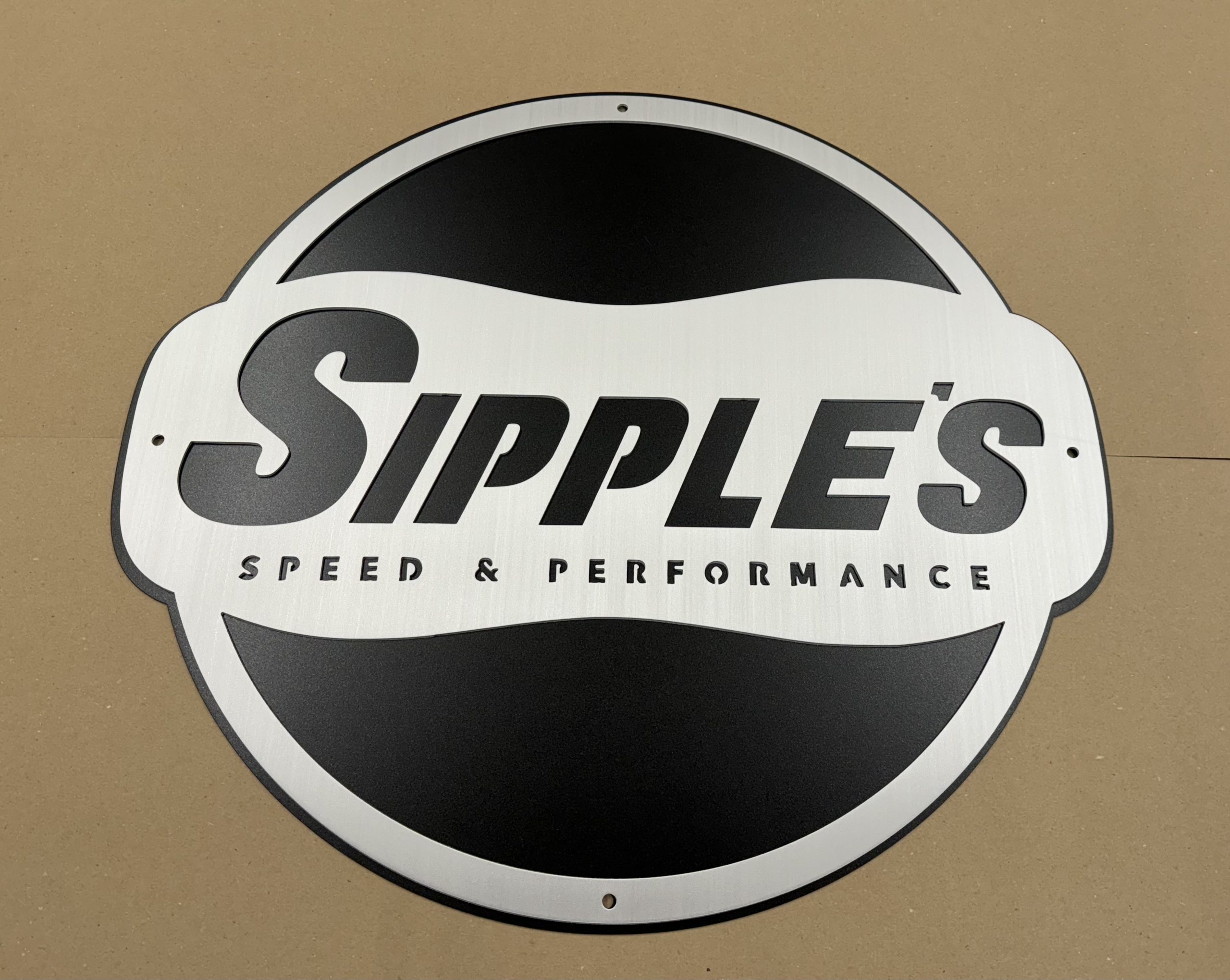 Custom round metal business sign for Sipple’s Speed and Performance.