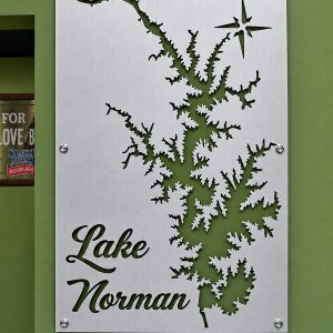Lake Norman brushed metal map with open shoreline cutouts, mounted on a green wall.